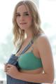 A woman in a green bra top holding a blue purse.